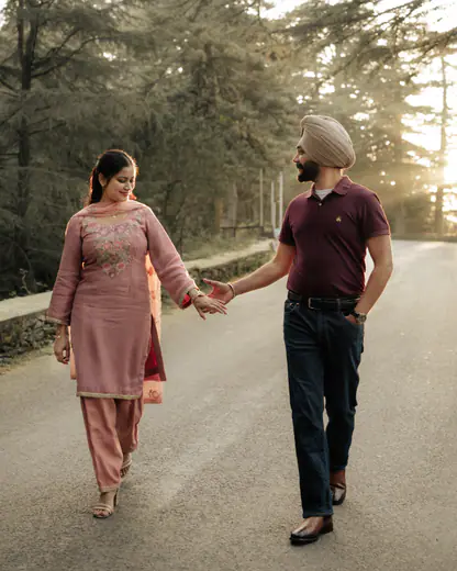 Couple walking hand in hand on a pine-lined road in the hills
